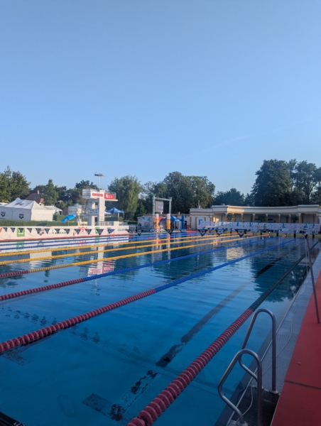 Schwimmbecken mit Startblöcken und Bahnen bei einem Wettkampf in Wien.