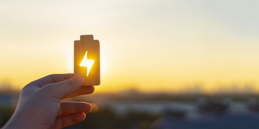 SPORTUNION Energietarife Hand hält ein Batterie-Icon in den Himmel.