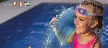 Mädchen mit Schwimmreifen und Taucherbrille am Beckenrand