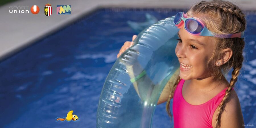 Mädchen mit Schwimmreifen und Taucherbrille am Beckenrand