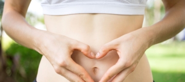 close-up-female-hands-shaping-heart-belly