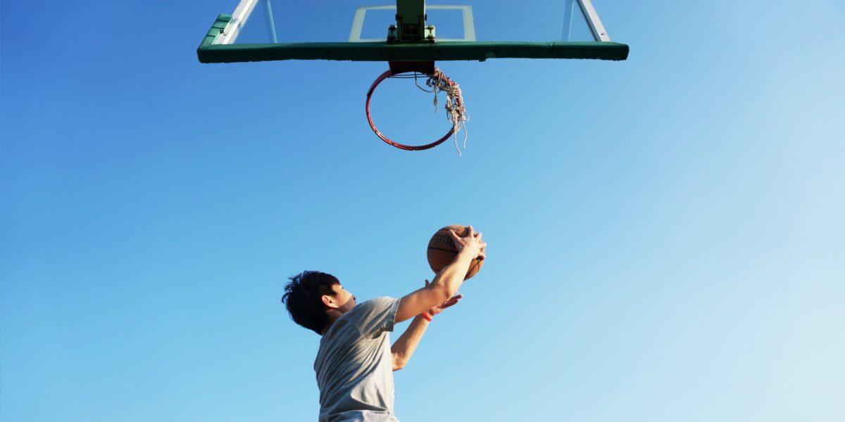 Mann wirft Basketballkorb