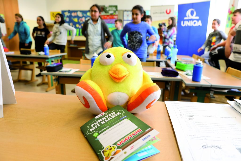 UGOTCHI Küken sitzt am Lehrertisch